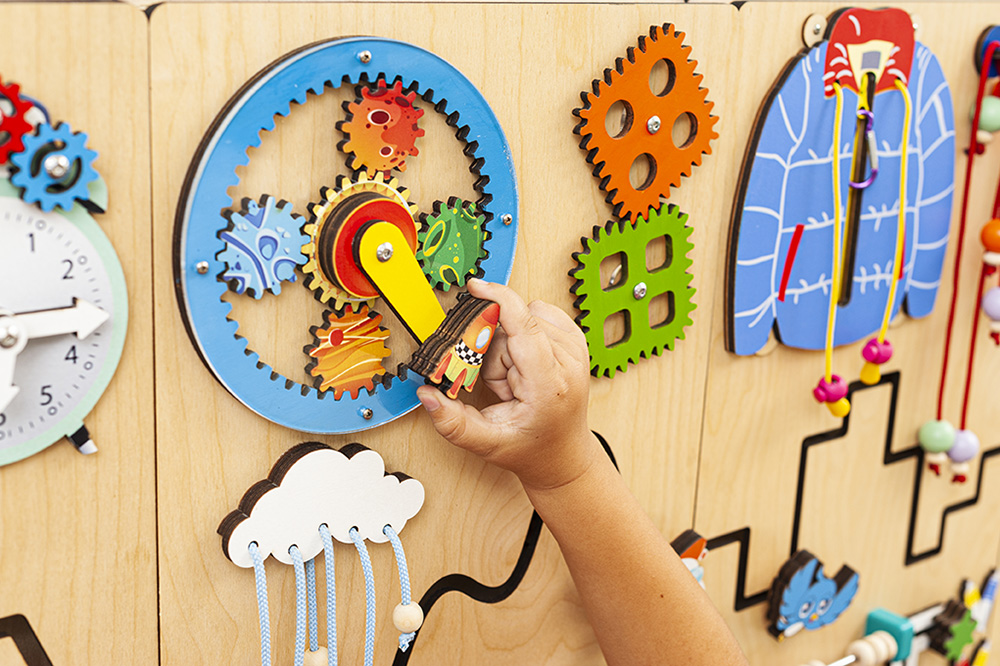 Busy board elements Close-up of locks, latches and gears on a busy board that build fine motor skills